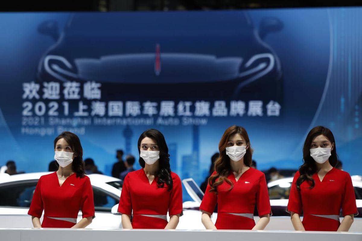 Wealthy Chinese customers suddenly risk losing out to Swiss banks: receptionists from a luxury car brand wait for visitors at a Shanghai auto show.