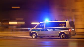 A police car with bright lights drives through the city center on New Year's Eve.  (Long exposure shot).  +++ dpa-Bildfunk +++