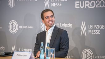 Philip Lahm laughs at a press conference about EM 2024.