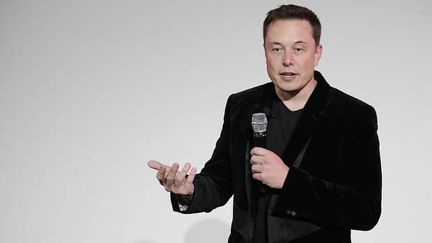Elon Musk presents a microphone on stage