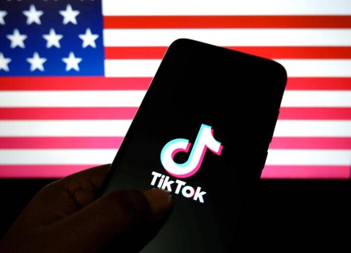 Logotipo de TikTok sobre un fondo con la bandera de Estados Unidos.