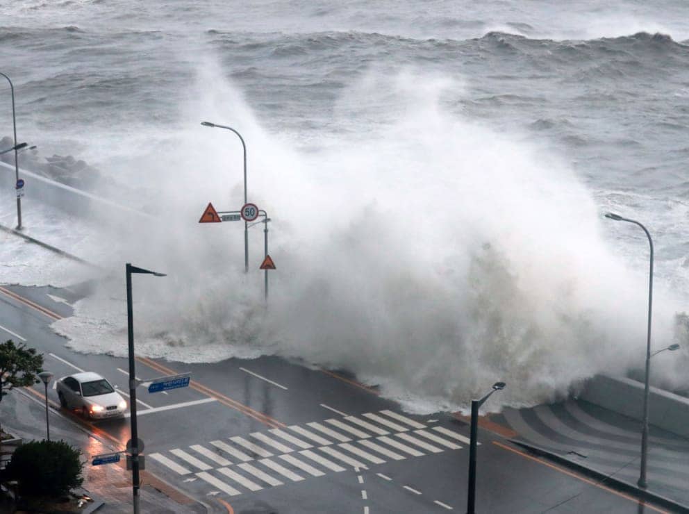 Huge waves crash against a sea wall in Busan