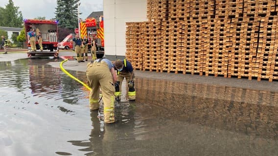 Two firefighters try to evacuate water collected in one place with euro boards.  © N.D.R. 