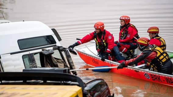 Erfstadt (North Rhine-Westphalia).  Water rescue workers use a boat to inspect trucks parked on flooded Federal Highway 265.  Photo: Marius Becker / DPA